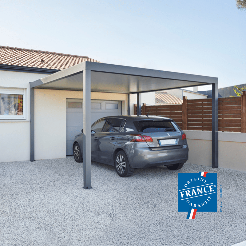 Carport ESSENTIEL Coclic Alu loin devant un garage
